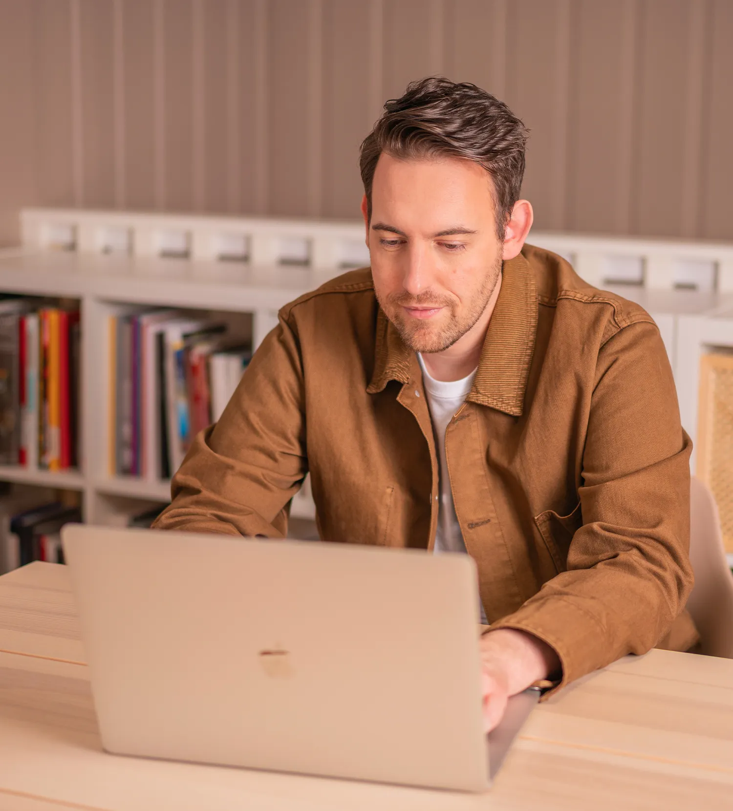 Bence Székely, advertising consultant, working on a laptop in a brown coat