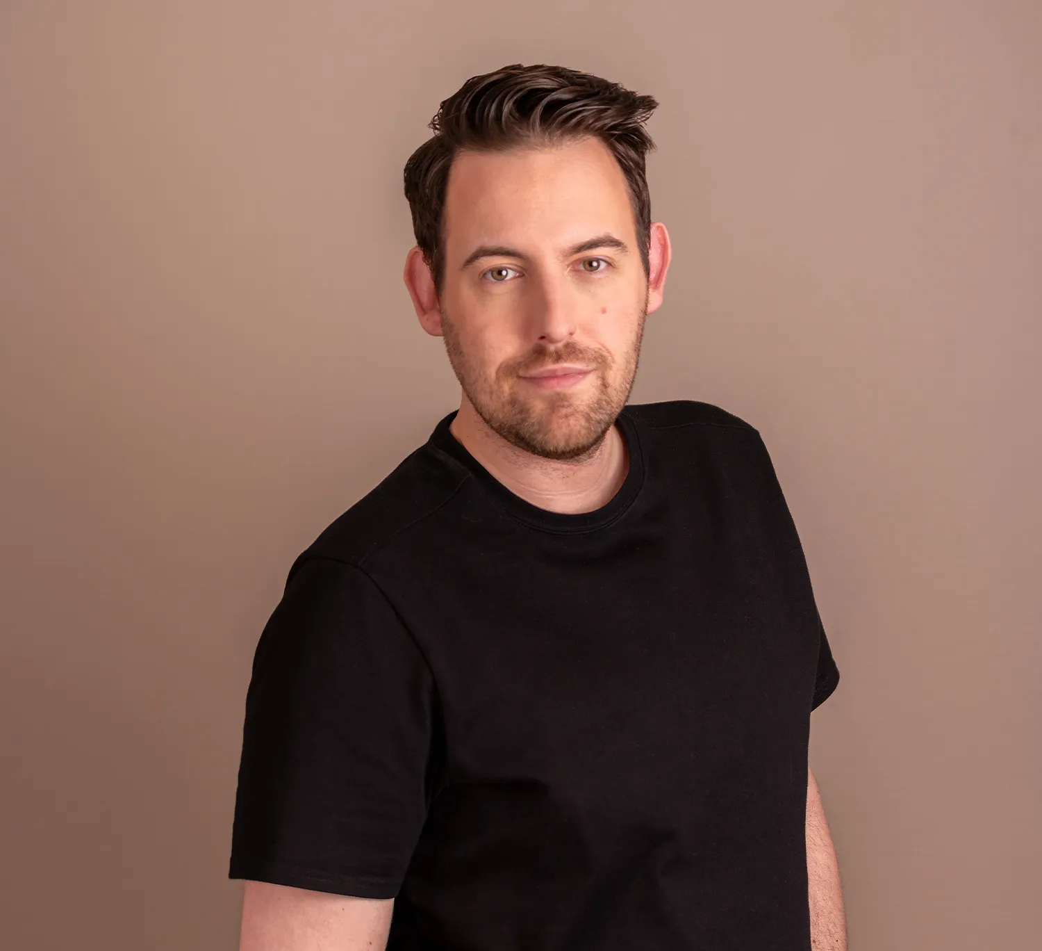 Bence Székely, marketing consultant, wearing a black t-shirt against a grey background